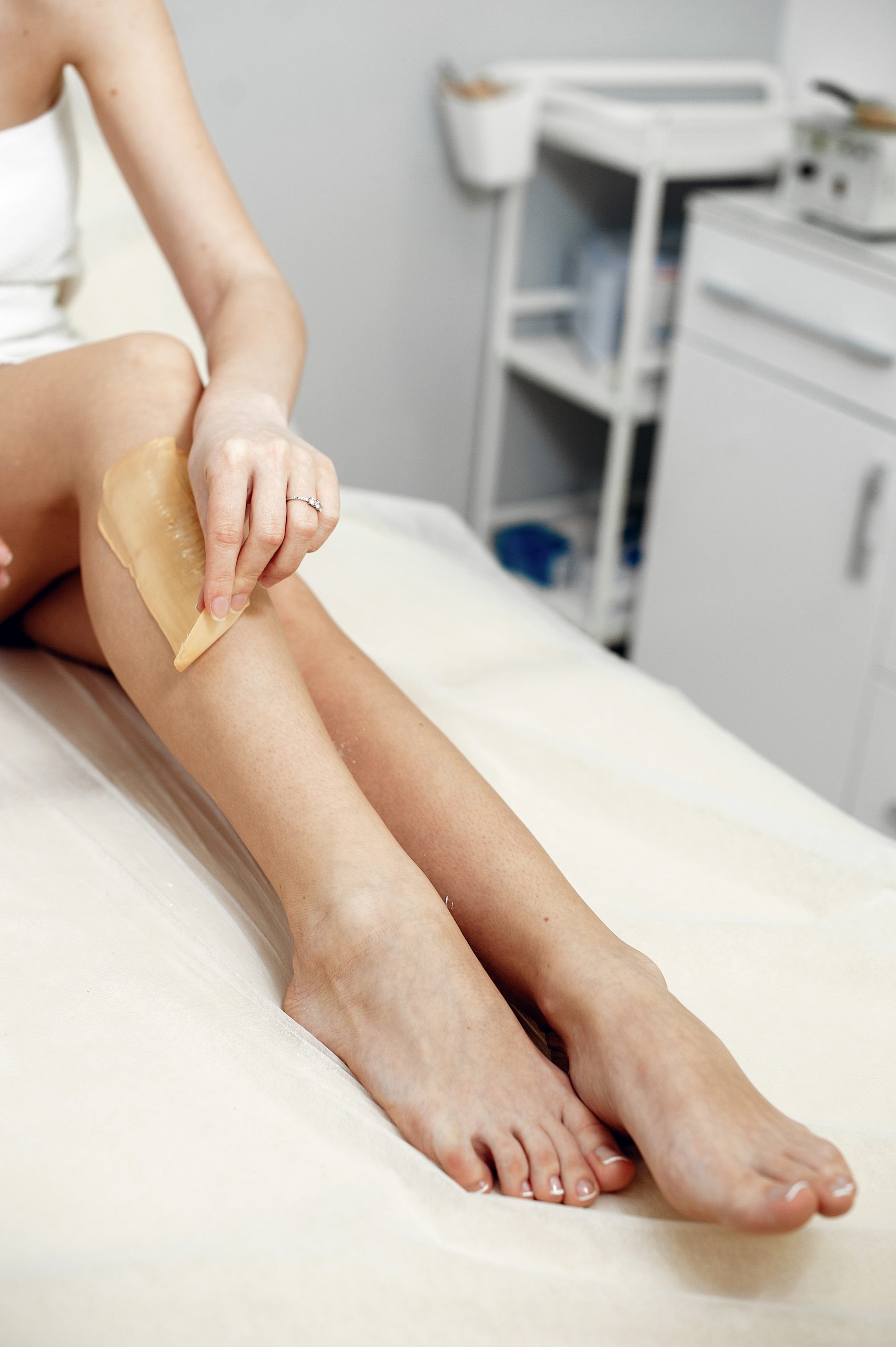 Beautiful girl doing hair removal. Woman in beauty salon
